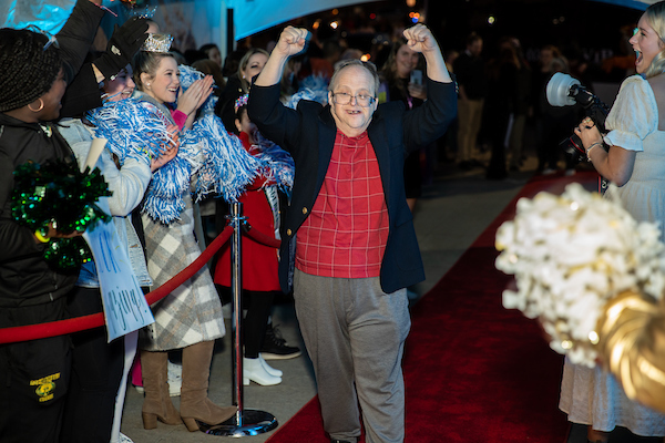 Man in red shirt and dark blazer enjoying the red carpet